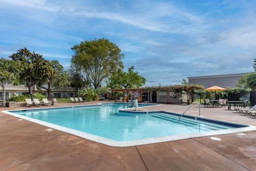 uma piscina num pátio com cadeiras e mesas em Best Western Plus Garden Court Inn em Fremont