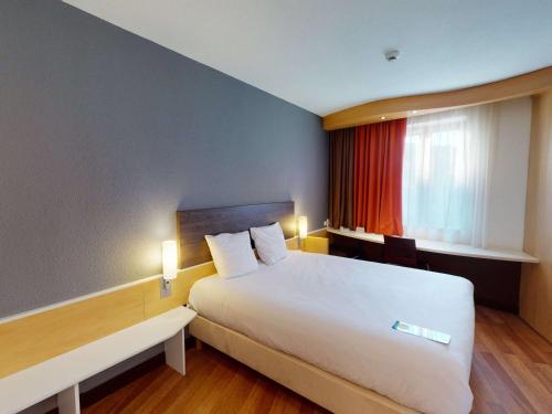 a hotel room with a large bed and a window at Ibis Bratislava Centrum in Bratislava