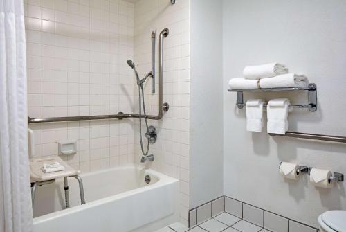 a bathroom with a tub and a toilet and towels at La Quinta by Wyndham Thousand Oaks-Newbury Park in Thousand Oaks