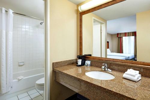 a bathroom with a sink and a toilet and a mirror at La Quinta by Wyndham Thousand Oaks-Newbury Park in Thousand Oaks