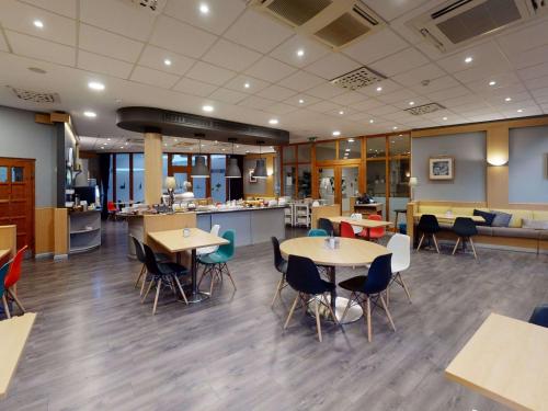 a restaurant with tables and chairs in a cafeteria at Ibis Bratislava Centrum in Bratislava