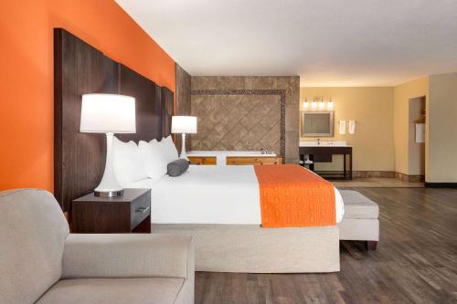 um quarto de hotel com uma cama grande e um sofá em Howard Johnson by Wyndham Pigeon Forge em Pigeon Forge