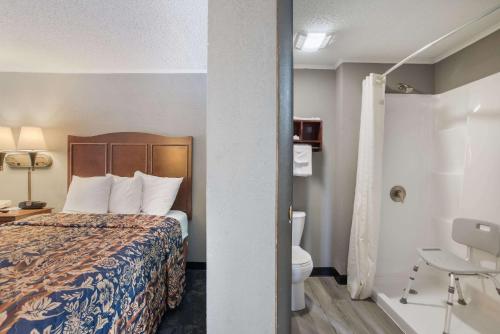 a hotel room with a bed and a toilet at Rodeway Inn in Carlisle