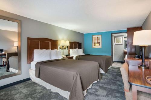 a hotel room with two beds with blue walls at Rodeway Inn Carlisle North in Carlisle