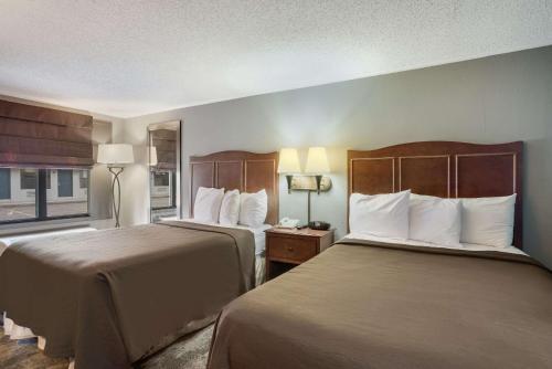 a hotel room with two beds and a window at Rodeway Inn Carlisle North in Carlisle
