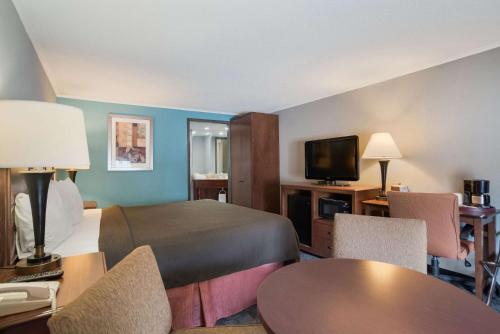a hotel room with a bed and a flat screen tv at Rodeway Inn Carlisle North in Carlisle