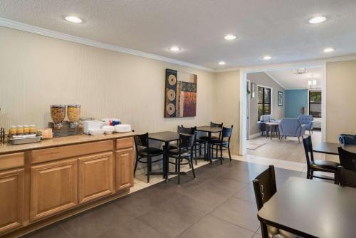 a dining room with tables and chairs and a kitchen at Rodeway Inn Carlisle North in Carlisle