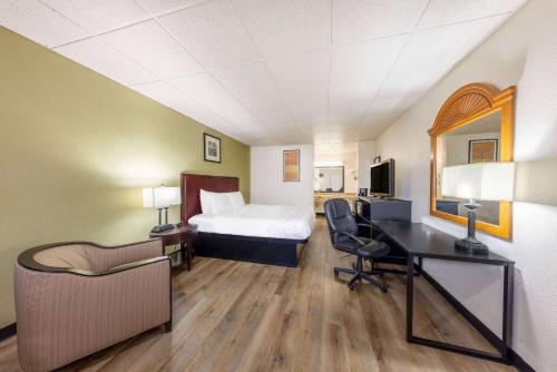 a hotel room with a bed and a desk at Baymont by Wyndham El Dorado in El Dorado