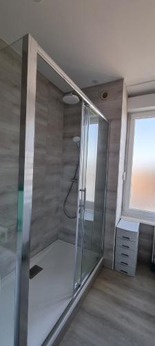 a glass shower in a room with a window at L'AUBERGADE in Vittel