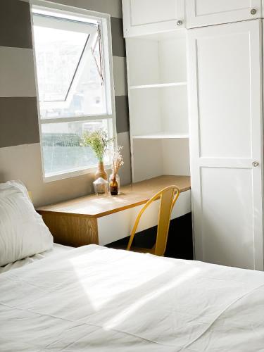 a bedroom with a bed and a desk with a window at B-HOMEAWAY in Ho Chi Minh City