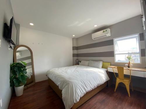 a bedroom with a bed and a table and a mirror at B-HOMEAWAY in Ho Chi Minh City