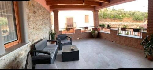 a balcony with couches and a table and windows at Tenuta il Giardino di Eros in Albanella