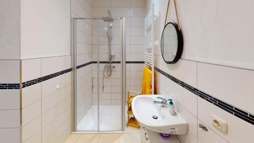 a white bathroom with a sink and a shower at Nina Apartments in Mühlhausen