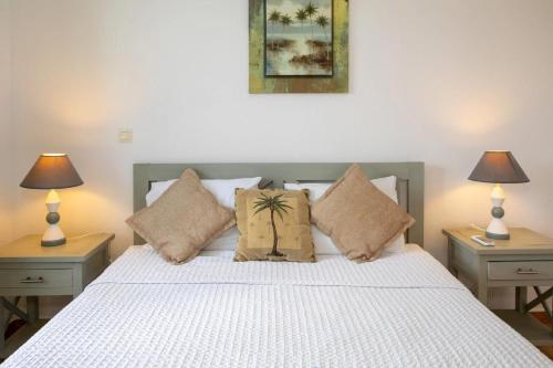 a bedroom with a white bed with two lamps at Blue BO in Orient Bay