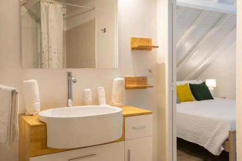 a white bathroom with a sink and a bed at Blue BO in Orient Bay