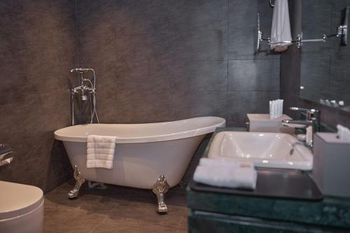 a bathroom with a tub and a toilet and a sink at Marvelous Hotel in Tabuk