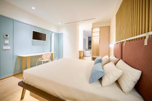 um quarto com uma grande cama branca com almofadas em Hotel Leonor Conil em Conil de la Frontera