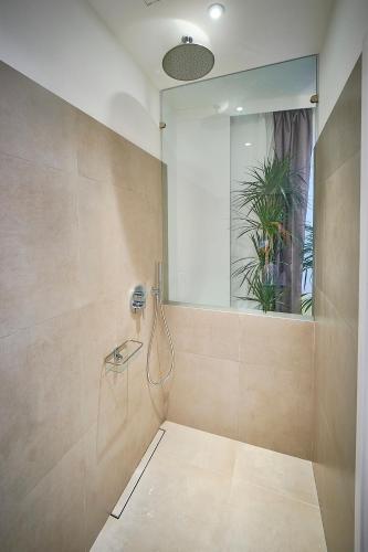 a bathroom with a shower with a phone on the wall at Hotel Leonor Conil in Conil de la Frontera