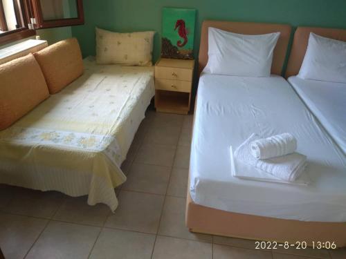two beds sitting next to each other in a room at Roula Rooms in Stratónion