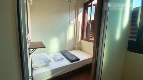 a small bed in a room with a window at 24 Kimberley in George Town