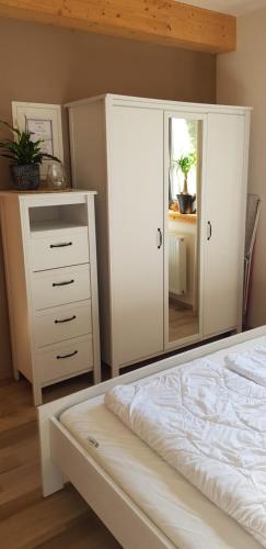 Schlafzimmer mit einem Bett, einer Kommode und einem Spiegel in der Unterkunft Neumühle Ferienwohnung 2 in Lutzerath