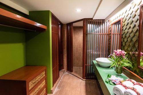 bagno con pareti verdi e lavandino di Dang Derm Khaosan a Bangkok