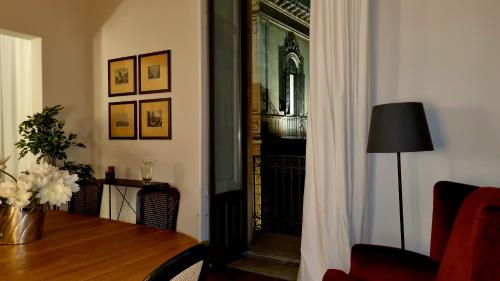 a living room with a table and a door to a balcony at La Renaissance in Catania