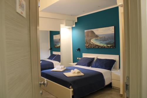 two beds in a hotel room with blue walls at B&B D'Amari Affittacamere in Palermo