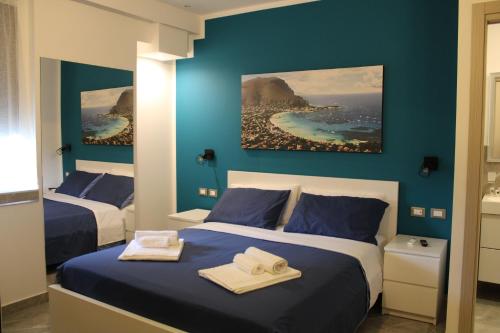two beds in a room with blue walls at B&B D'Amari Affittacamere in Palermo
