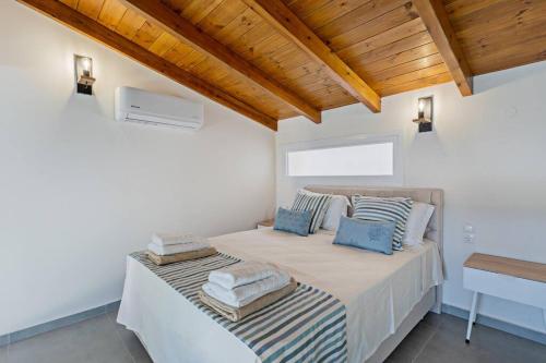 a white bedroom with a bed with towels on it at Sofia Suite, a seafront hideaway ! in Panormos Rethymno