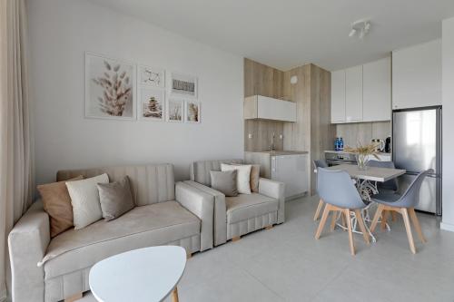 a living room with a couch and a table at Downtown Apartments Seaside Gdańsk Letnica in Gdańsk