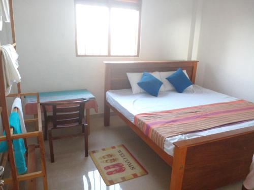 a small bedroom with a bed and a table at Galle City Nest in Galle