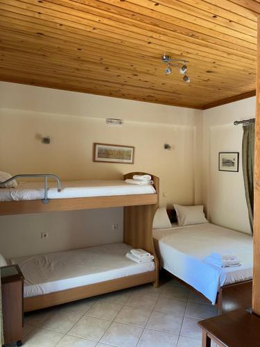 2 Etagenbetten in einem Zimmer mit Holzdecke in der Unterkunft Villa Agni in Yénion