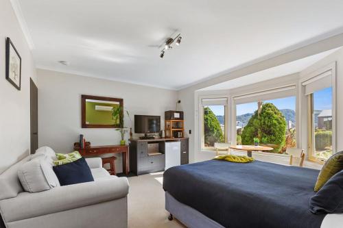 a bedroom with a bed and a couch and a window at Stay Inn in Apollo Bay
