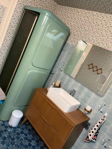 La salle de bains est pourvue d'un lavabo et d'un miroir. dans l'établissement Gîte du centre, à Romorantin-Lanthenay