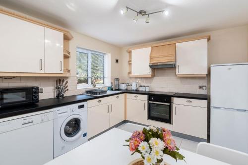 a kitchen with white appliances and a table with flowers at Boulevard View in Doncaster