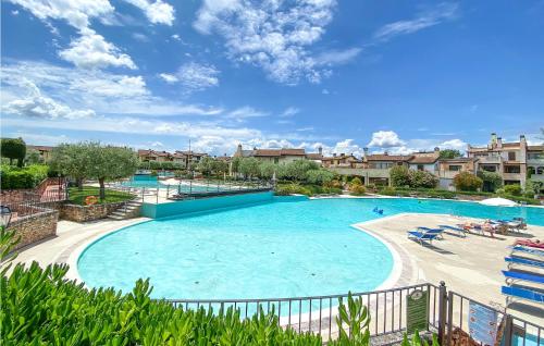 uma grande piscina num resort com pessoas em cadeiras em Trilo Superior em Peschiera del Garda