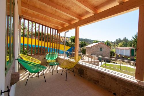 a balcony with chairs and a view of a yard at A Casa Do Boi in Amés