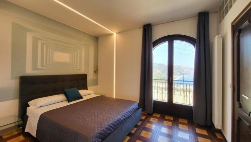 a bedroom with a bed and a large window at I Due Grifoni Luxury Apartment & Spa in Taormina