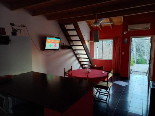 - un salon avec une table et une télévision murale dans l'établissement Rinconada 1, à Las Grutas