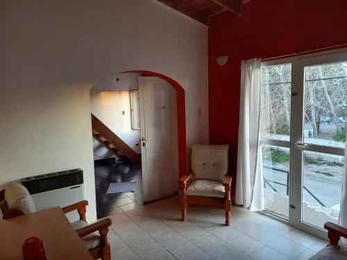 ein Wohnzimmer mit einem Stuhl und einem Spiegel in der Unterkunft Rinconada 1 in Las Grutas