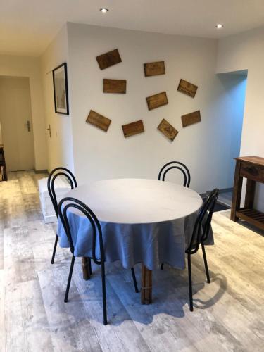 une table blanche avec des chaises et un mur avec des flèches dans l'établissement Les gîtes de criquetot, à Criquetot-le-Mauconduit