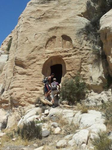 a couple of people standing in front of a rock tunnel at Dana moon hostel in Dana