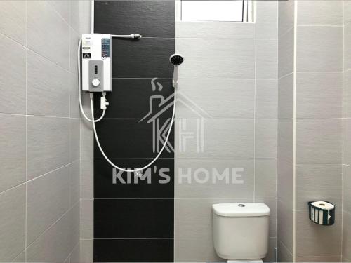 un baño con aseo y una pared con escritura. en Kim’s Home - Homey At Your Stay, en Nibung Tebal