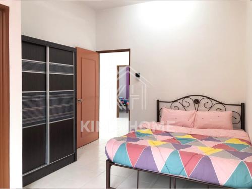 a bedroom with a bed with a colorful bedspread at Kim’s Home - Homey At Your Stay in Nibung Tebal