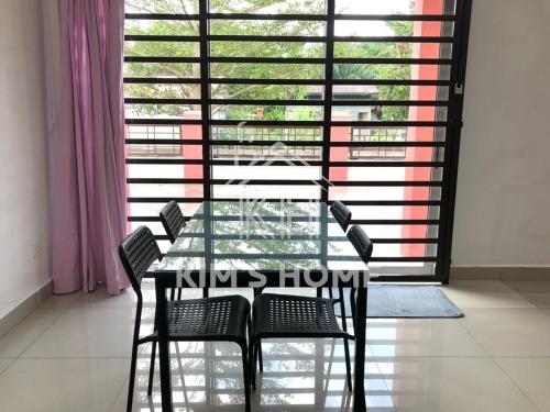 una mesa y sillas frente a una gran ventana en Kim’s Home - Homey At Your Stay, en Nibung Tebal