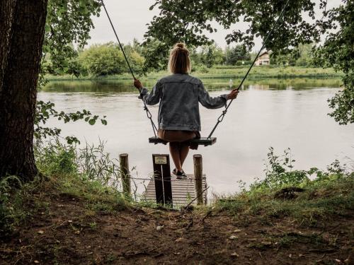 a woman on a swing over a lake at Promowa17 in Rogóźno