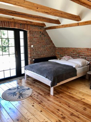 a bedroom with a bed and a brick wall at Dom w Dolinie Zdrowia in Wleń