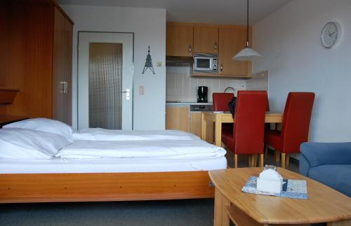 1 dormitorio con cama, mesa y cocina en Haus Trafalgar Whg. 242 Möwennest, en Cuxhaven