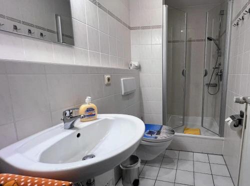 a bathroom with a sink and a shower and a toilet at Haus Trafalgar Whg. 242 Möwennest in Cuxhaven